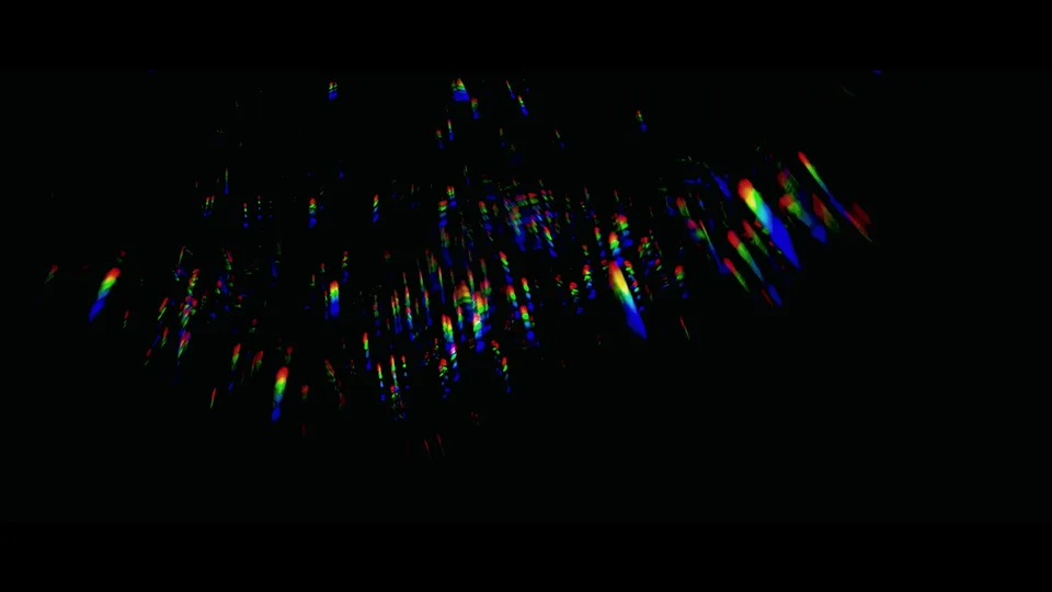 Still from Andrés’s camera test showing coloured points of light on a dark background