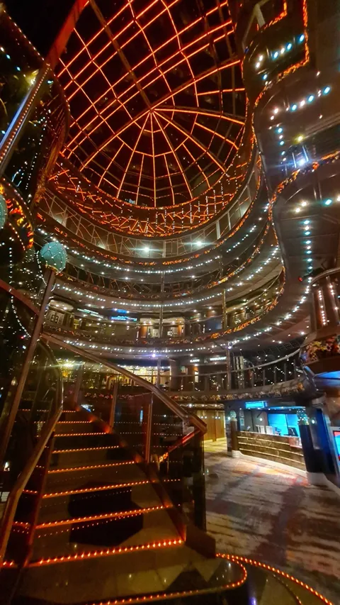 A cruise ship atrium glowing with warm orange lights